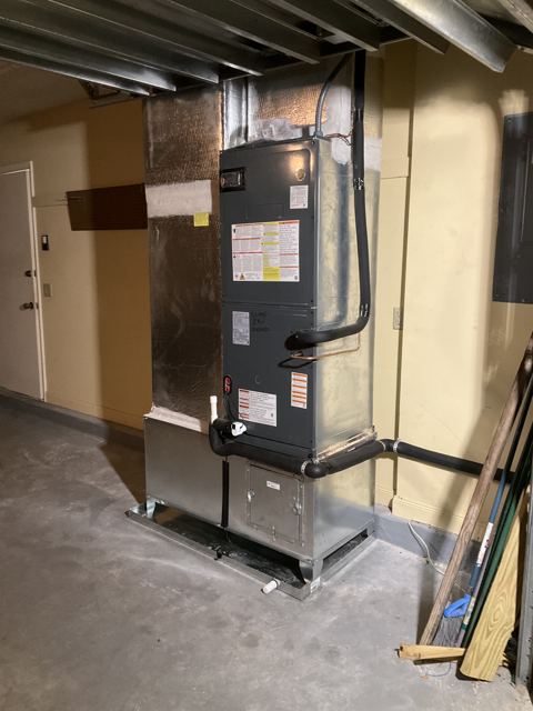 Garage mechanical-room unit — Air handler set on a steel stand with sealed supply transition (Wonder Air & Heat, Brevard County FL)