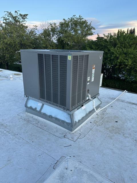 Packaged unit on a new curb — Rooftop package unit set on a fresh curb over a white TPO roof (Wonder Air & Heat, Brevard County FL)