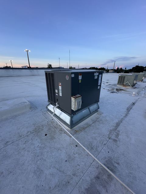 Rooftop package unit at dusk — Commercial package unit installed and wired, ready for startup (Wonder Air & Heat, Brevard County FL)