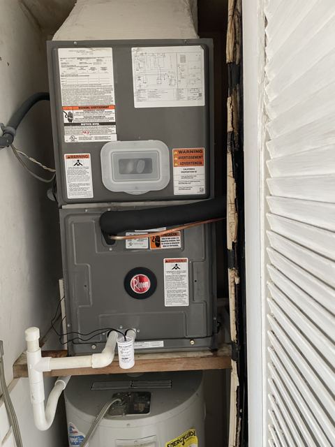 Utility-closet install — Stacked over the water heater with Safe-T-Switch overflow protection (Wonder Air & Heat, Brevard County FL)