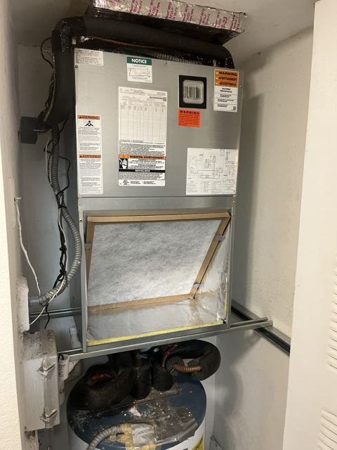 Closet unit over water heater — Filter rack access preserved in a shared utility closet (Wonder Air & Heat, Brevard County FL)
