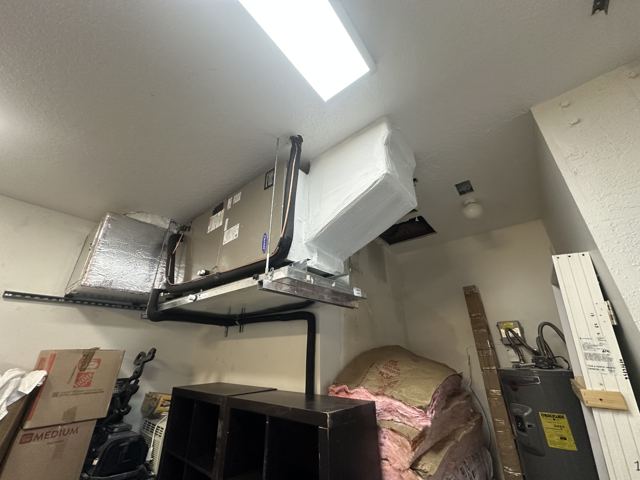 Suspended horizontal install — Ceiling-mounted unit with fresh insulation wrap and trapeze hangers (Wonder Air & Heat, Brevard County FL)